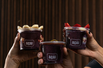 Mix of Delicious Brazilian Açaí Cream, in a plastic Cup With a variety of Toppings. Summer acai smoothie