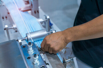 hand with mask with automatic machine for the manufacture of medical masks with nanofiber. Coronavirus and Covid-19 Protection