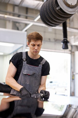 hard-working auto mechanic worker polishing car at automobile repair service, renew service station...