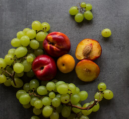 Still life with juicy summer fruits. Top view photo on dark background with copy space. Fresh colorful fruits in a glass vase.