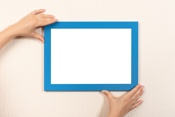 mockup diploma. woman hanging photo frame mockup on wall. White frame mockup. horizontal