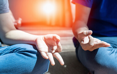 Meditate yoga hands of elderly woman doing meditation in silhouette sunset and lens flair effect.Healthcare, lifestyle concept. International Yoga Awareness Day
