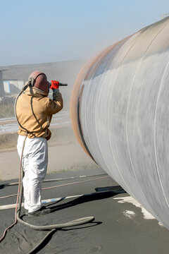 The sandblaster is sanding to steel pipe material. Sand blasting is also known as abrasive blasting, which is a generic term for the process of smoothing, shaping and cleaning a hard surface.