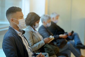 Patients sitting in waiting room with face mask, COVID-19 pandemic - 389654449