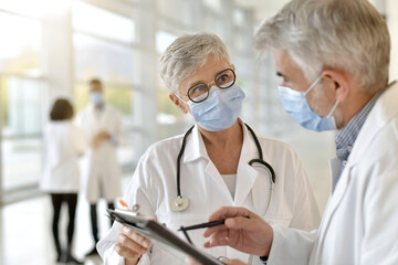 Doctor in hospital giving 19-ncov instructions to colleague