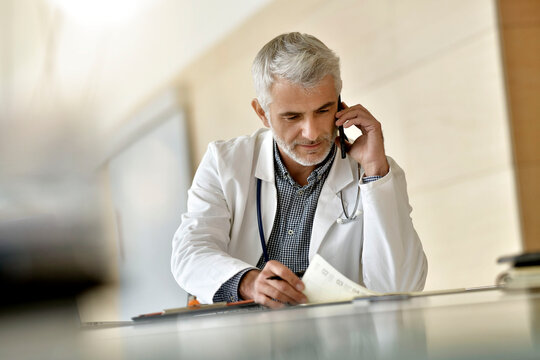 Doctor giving advice to patient by phone - social distancing consultation