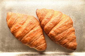 Fragrant homemade croissant, close-up, on a wooden table.