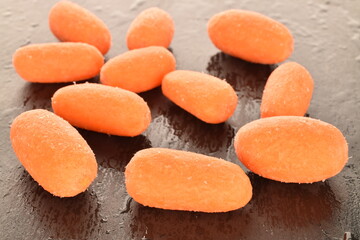 Ripe juicy organic mini carrots, close-up, on a slate board.