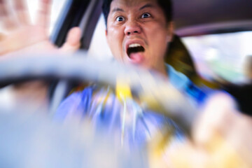 Young man driving a car shocked about to have traffic accident, windshield view. Blurred focus concept