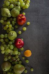 Colorful juicy fruits border.  Fresh summer fruits top view horizontal photo. Dark grey background with copy space. 