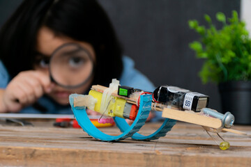 A cute Asian girl is learning to assemble a robot during school hours, a start to learn innovation concept