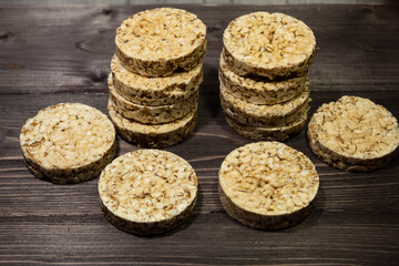 Whole grain crispbreads for weight loss lie on a dark wooden background..
