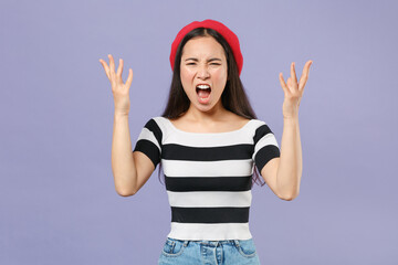 Obraz na płótnie Canvas Angry irritated young brunette asian woman 20s wearing casual striped t-shirt red beret spreading hands screaming swearing looking camera isolated on pastel violet colour background studio portrait.
