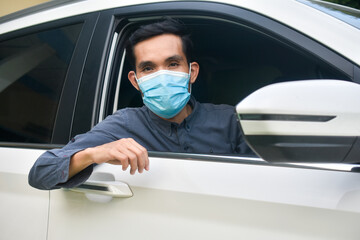 Fototapeta na wymiar Asian man wear face mask sitting in car protect coronavirus covid 19
