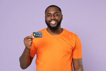 Smiling funny young african american man 20s wearing basic casual orange blank empty t-shirt...