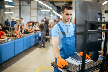 Bicycle factory, worker manages bike assembly line