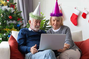Senior retirement couple connect computer laptop during Christmas celebration in their living room