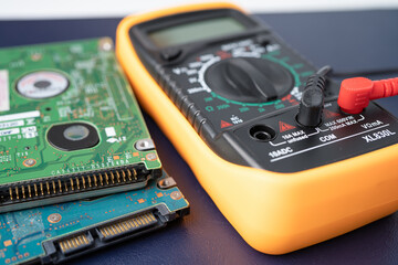 Multimeter with harddisk, maintenance, repairing and checking computer hardware concept.