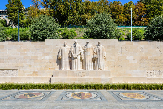 Front view of the four statues at the center of the Reformation Wall in the Parc des Bastions in Geneva, Switzerland, representing John Calvin and the Calvinism's main proponents, on a sunny day.