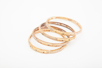 Set of golden bracelets on white background with selective focus