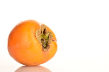 Ripe juicy organic persimmon, close-up, on a white background.