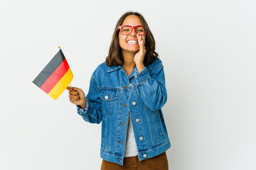 Young latin woman holding a german flag isolated on white background