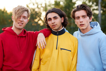 friendly modern guys 16 years old posing at camera in city streets, sportive youth concept