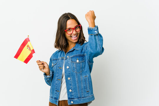 Young spanish woman holding a flag isolated on white background