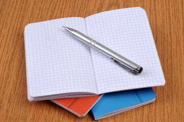 Stylo sur des carnets posés sur un bureau