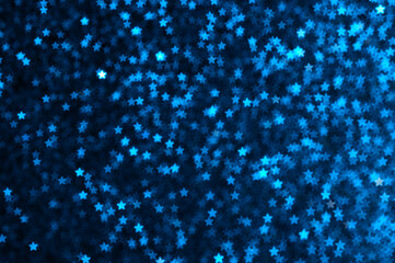 Blue holiday glitter background with stars bokeh.