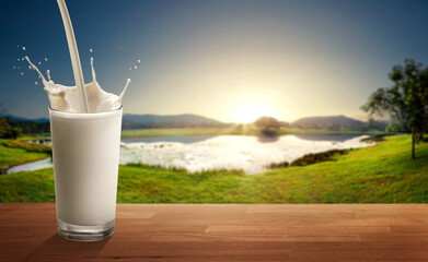 Outdoor lakeside nature background and milk pouring into glass