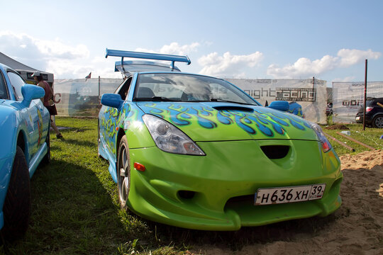 Moscow, Russia - May 25, 2019: Tuned car Toyota Celica T23 with airbrushing blue and green in the form of a flame. It is in the field.