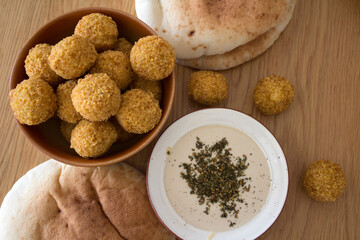 Israeli food close up photo. Falafels, hummea and pita bread on a table. 