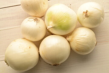 Juicy organic white onion, close-up, on a white wooden table.
