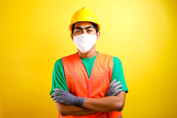 Asian constructor worker man with mask and safety vest crossed his arm