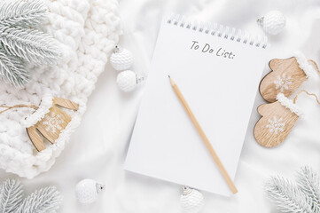 Christmas decorations and notepad with to do list or goals and dreams on white background. Flat lay, top view, copy space.