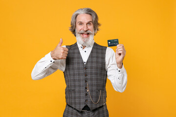 Cheerful elderly gray-haired business man in checkered waistcoat white shirt hold credit bank card...