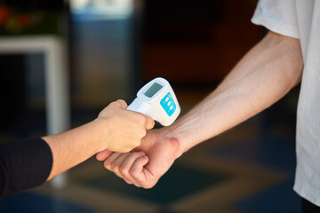 close-up disease control expert use an infrared thermometer equipment to check the temperature of...