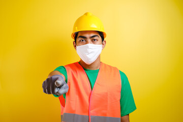 asian construction worker wearing protective mask pointing forward