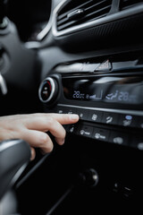 Interior view of a new car. Climate or air conditioner system adjusted by a woman. Adjusting temperature of car's interior