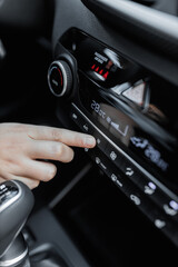 Interior view of a new car. Climate or air conditioner system adjusted by a woman. Adjusting...