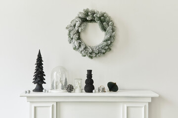 Christmas composition on the white chimney at the living room interior with beautiful decoration. Christmas tree and wreath, candles, stars, light. Copy space.  Template.