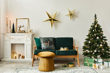 Stylish christmas living room interior with green sofa, white chimney, christmas tree and wreath, stars, gifts and decoration. Family time. Template.