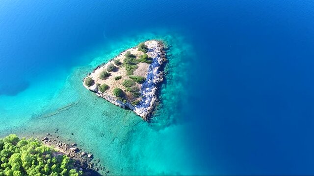 Aerial view of Siderona bay with islet, Corinthia, Greece, on a lovely bright day in a calm blue and turquoise sea
