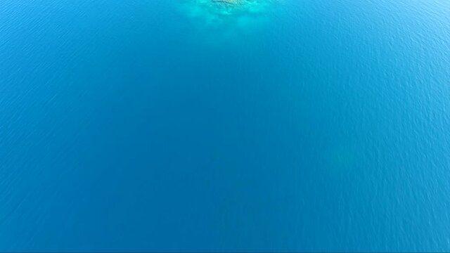 Aerial view of Siderona bay with islet, Corinthia, Greece, on a lovely bright day in a calm blue and turquoise sea