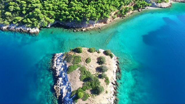 Aerial view of Siderona bay with islet, Corinthia, Greece, on a lovely bright day in a calm blue and turquoise sea