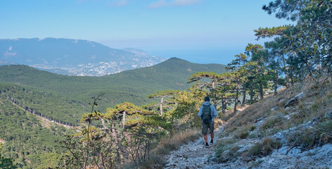 Fototapeta na wymiar the southern Crimea. Scenic slope of Ai Petri mountain. A man with a backpack is walking along the rocky mountain trail.