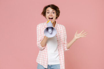 Excited surprised shocked amazed young brunette woman 20s wearing casual checkered shirt standing...