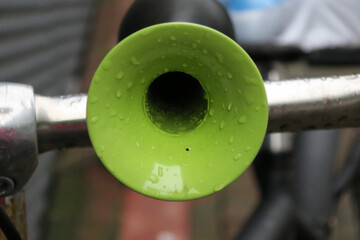 green horn with raindrops on the handlebar of a bicycle