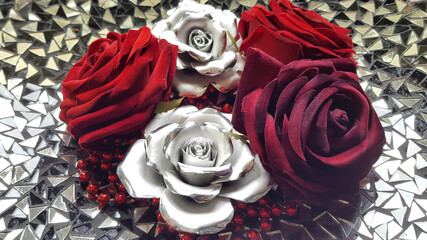 Red and silver roses on mirror background